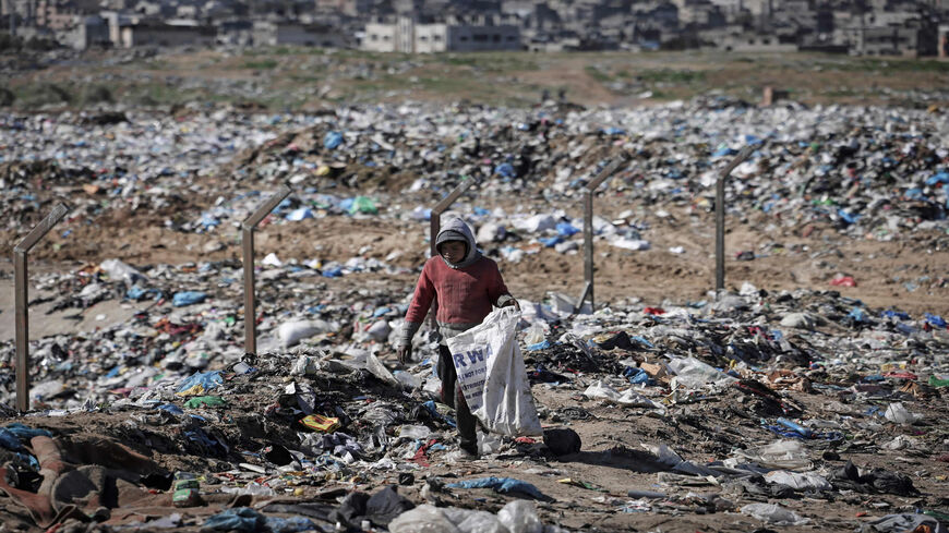 A Palestinian youth collects plastic and iron from a landfill in Beit Lahiya, Gaza Strip, Jan. 17, 2022.