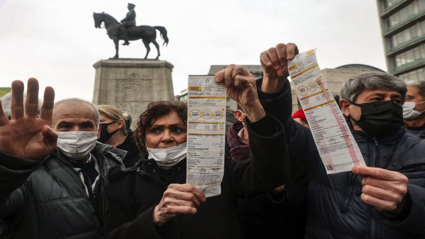 People hold up their electricity bills as they protest against high energy prices in Ankara on Feb. 9, 2022.