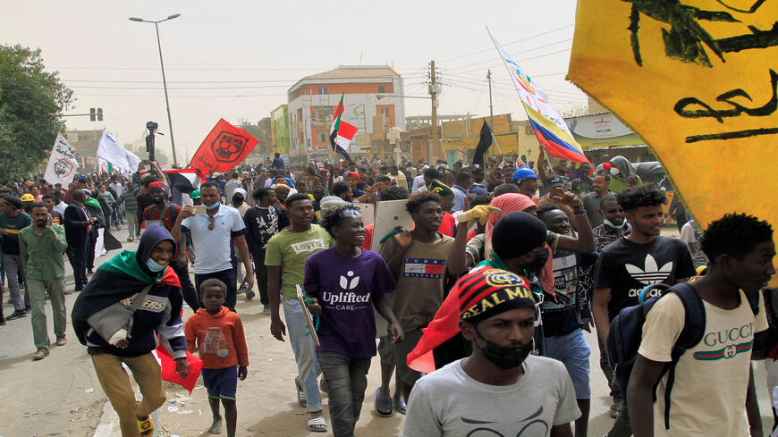 Demonstrators march with flags of Sudan and Venezuela (without the stars) during ongoing protests calling for civilian rule and denouncing the military administration, in the Sahafa neighborhood, Khartoum, Sudan, Feb. 20, 2022.