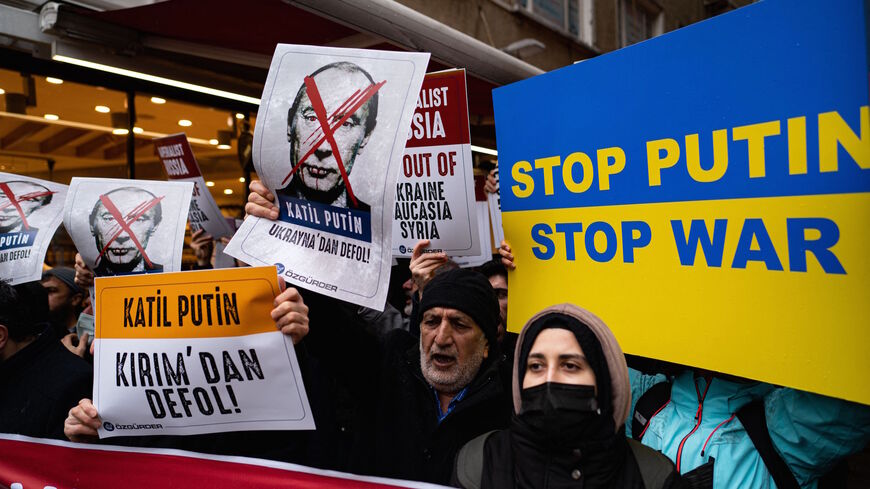Demonstrators hold placards during a protest against Russia's military operation in Ukraine in front of the Russian embassy in Istanbul on February 24, 2022. - Russia's President has launched a military operation in Ukraine on February 24, 2022 after weeks of intense diplomacy and the imposition of Western sanctions on Russia that failed to deter him. (Photo by Yasin AKGUL / AFP) (Photo by YASIN AKGUL/AFP via Getty Images)