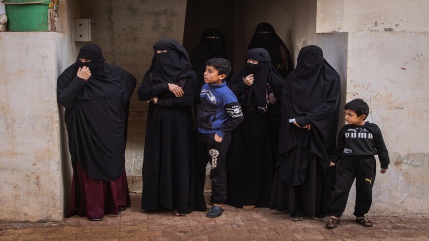 Orphan Syrian children and displaced widows wait for food aid at El Ardiye orphanage, Idlib, on Nov. 26, 2021.