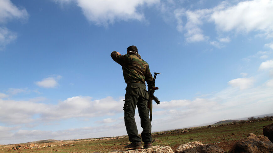 A Syrian soldier looks over at the town of Daraa from his position in the southern city of Sweida on Jan. 23, 2013. 