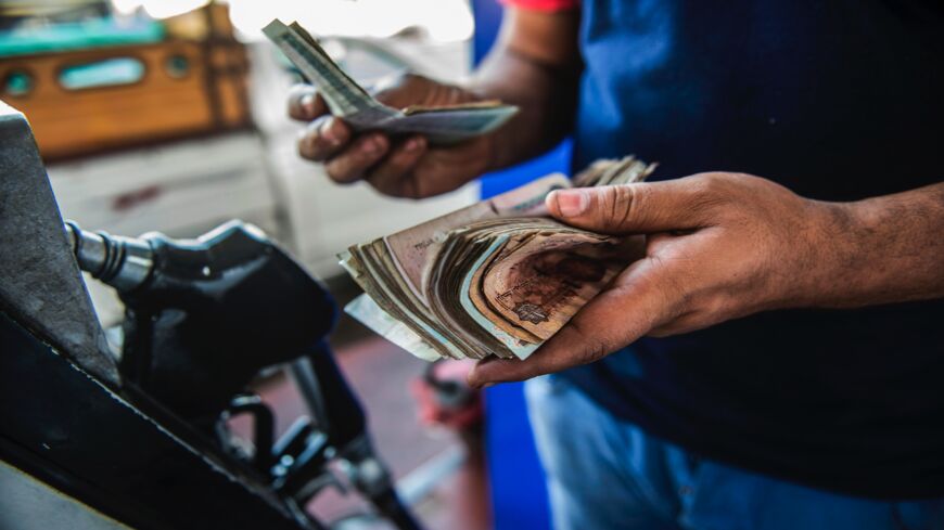 An Egyptian petrol station worker counts cash in Cairo on June 29, 2017. 