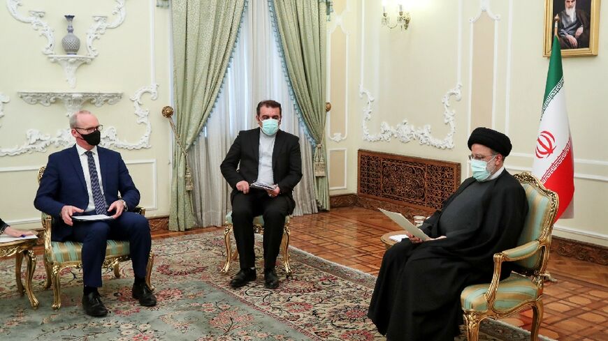 A handout picture provided by the Iranian President Ebrahim Raisi's office shows him (R) with Irish Foreign Minister Simon Coveney (L) in the capital Tehran