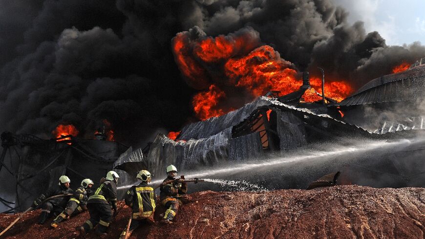 Syrian firefighters battle a blaze in a fuel depot triggered by shelling of the rebel-held Idlib region by government forces
