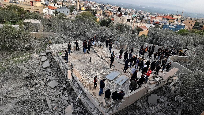 Palestinians gather on the ruins of a Palestinian house demolished by Israeli forces, in the village of Silat al-Harithiya near the flashpoint town of Jenin in the occupied West Bank, on March 8, 2022