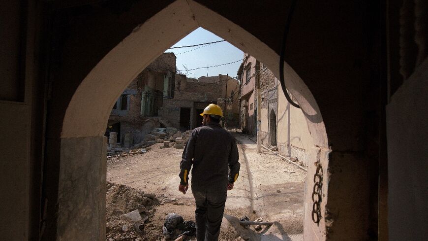 An Iraqi architect exits a traditional house during renovations in the Old Town of Mosul, which was reduced to rubble during fighting to expel jihadists