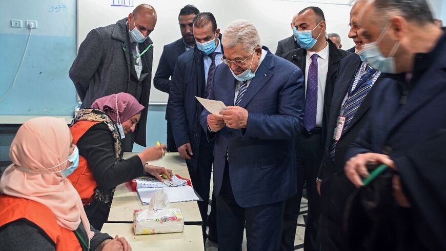 A handout picture provided by the Palestinian Authority's press office (PPO) shows President Mahmud Abbas (C) as he votes in the local elections, in Ramallah in the occupied West Bank, on March 26, 2022