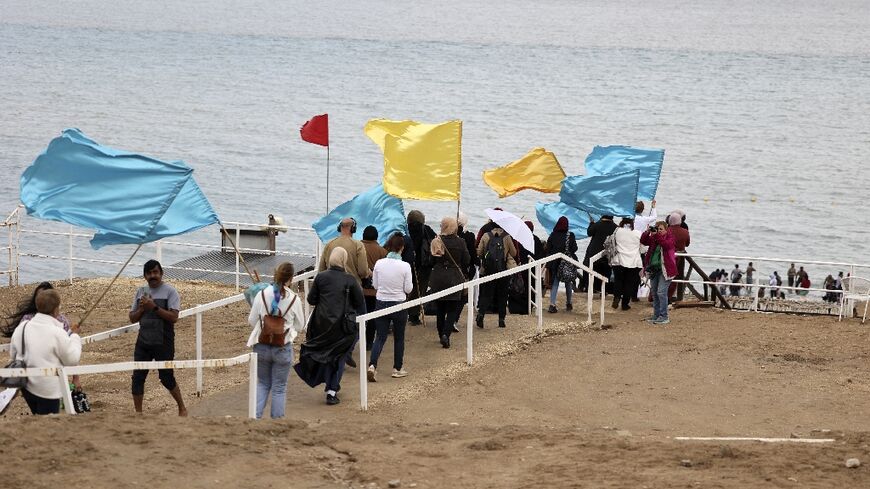 Israeli and Palestinian women wave their flags as they take part in an inaugural event of a peace partnership on the shore of the Dead Sea near the West Bank city of Jericho