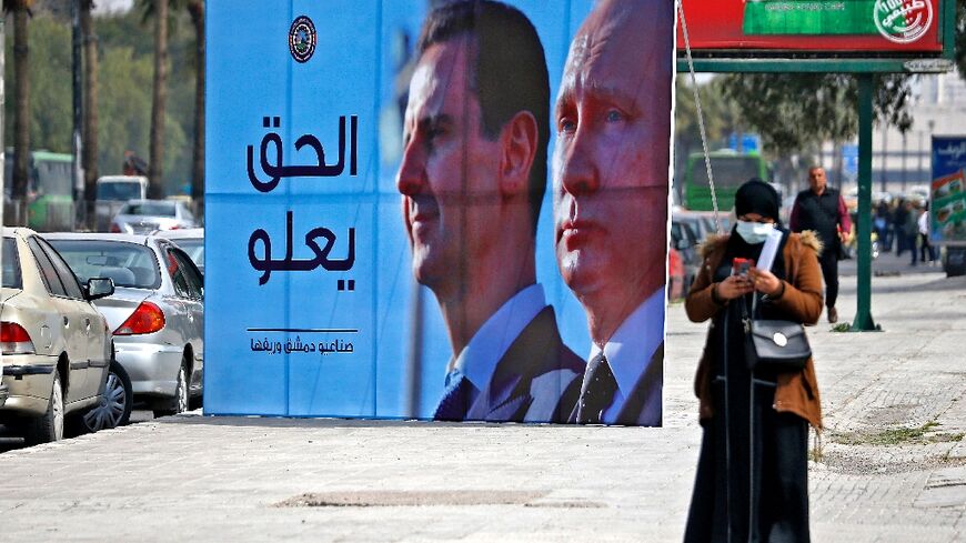 A banner depicting Syrian President Bashar al-Assad and Russian President Vladimir Putin and reading "Justice Prevails", is displayed along a highway in the Syrian capital Damascus, on March 8, 2022
