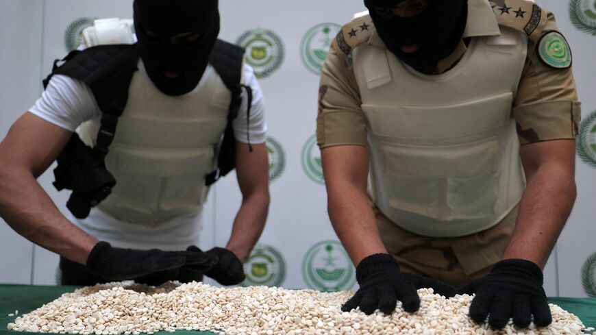 Officers with the Directorate of Narcotics Control of Saudi Arabia's Interior Ministry sort through tablets of Captagon seized during a special operation and shown to AFP afterwards in the Red Sea coastal city of Jeddah 
