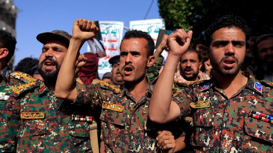 Soldiers loyal to Yemen's Huthi rebels join a rally in the rebel-held capital Sanaa marking the seventh anniversary of a Saudi-led coalition's military intervention in the country's devastating civil war
