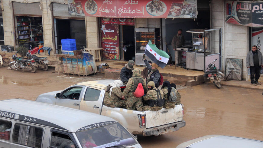 Members of the Free Syrian Army wave the flag of the Syrian opposition as they travel in a truck through the town of Hazano, in Idlib's northern countryside, as reinforcements are deployed from Aleppo's northern countryside to Idlib's countryside to counter an ongoing pro-regime offensive, Syria, Feb. 5, 2020.