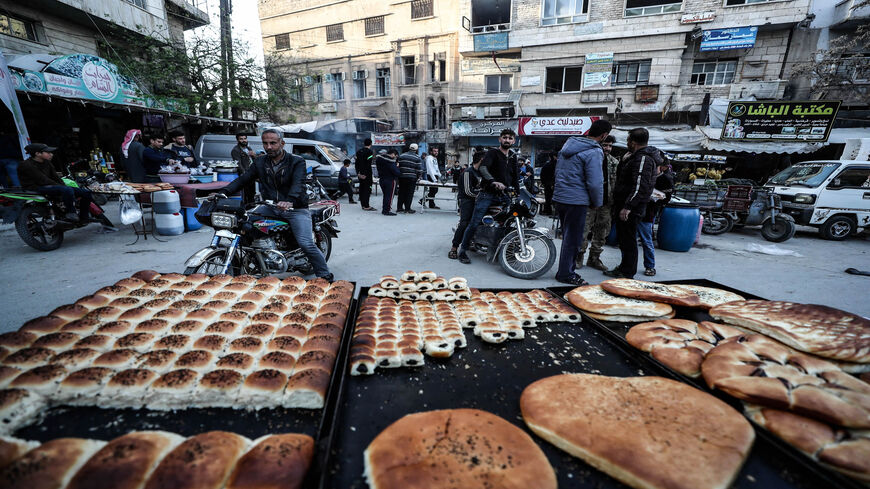 A street vendor displays pastries and bread, as Syrians buy food products at a market ahead of iftar, the evening meal that ends the daily fast at sunset, on the second day of the Islamic holy month of Ramadan, Ariha, Idlib province, Syria, April 15, 2021.