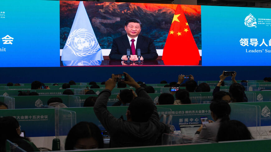 Media staff members watch a live image of China's President Xi Jinping speaking at the media center of the United Nations Biodiversity Conference, Kunming, Yunnan province, China, Oct. 12, 2021.