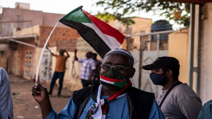 A man waves a flag at a Day of Resistance protest on Nov. 13, 2021, in Omdurman, Sudan.