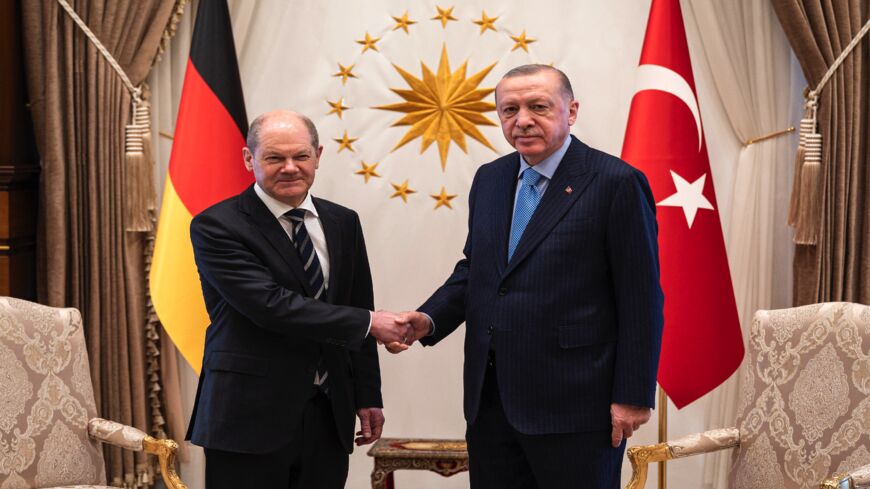 Chancellor Olaf Scholz (L) and Turkish President Recep Tayyip Erdogan shake hands.