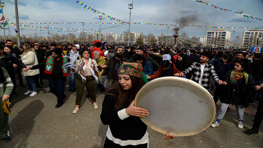 A woman plays a daf drum as people peform the Halay folk dance during a gathering of Turkish Kurds for Nowruz celebrations marking the Persian New Year in Diyarbakir, southeastern Turkey, March 21, 2022.