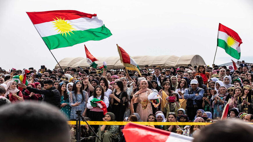 People wave the Kurdish flag during a Syrian Kurdish celebration marking Nowruz in the town of Qahtaniyah, Hasakah province, Syria, March 21, 2022.