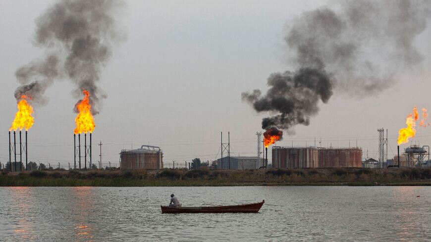 A boat passes polluting gas flares at the Umm Qasr port near Iraq's southern city of Basra 