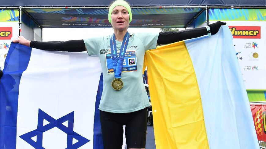 Ukrainian athlete Valentyna Veretska holds the Israeli and Ukranian flags after winning the Jerusalem marathon