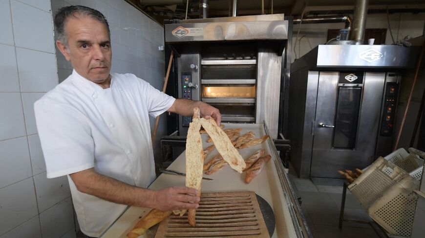 Master baker Taoufik inspects bread at his bakery in the El Menzah area of the Tunisian capital