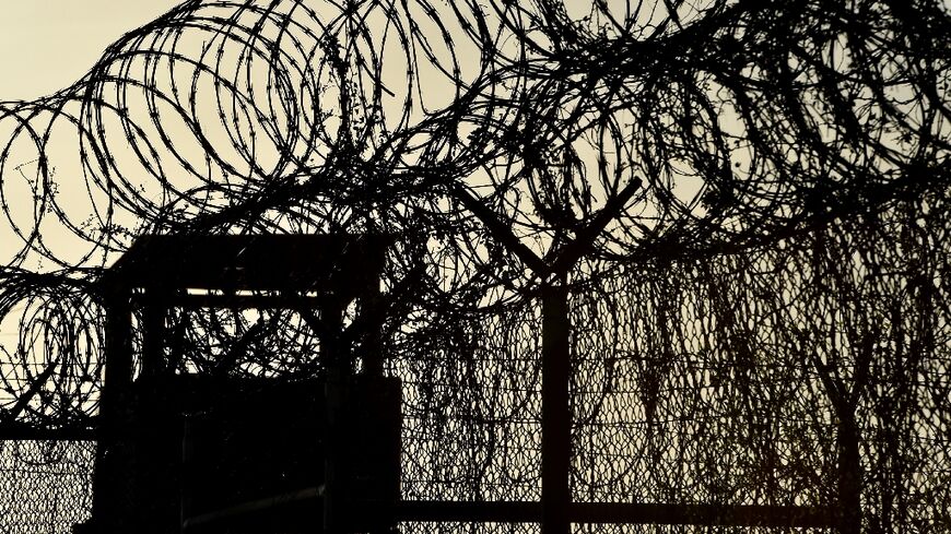 In this file photo taken on April 09, 2014, made during an escorted visit and reviewed by the US military, shows the razor wire-topped fence and a watch tower at the abandoned "Camp X-Ray" detention facility at the US Naval Station in Guantanamo Bay, Cuba