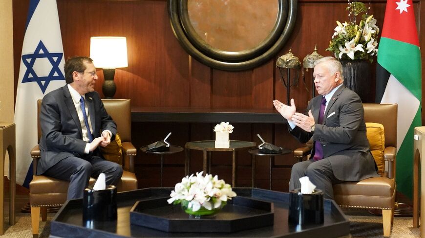 A handout picture released by the Jordanian Royal Palace shows Jordan's King Abdullah II and Israeli President Isaac Herzog talking during a meeting in the capital Amman