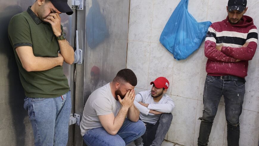 Palestinian men mourn a man shot dead, at the morgue of a hospital in Jenin in the occupied West Bank, on April 27, 2022