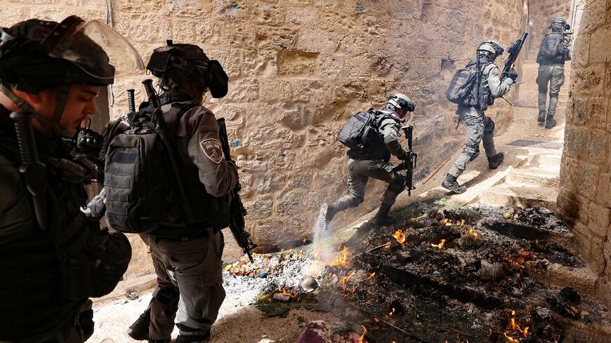 Israeli police pursue Palestinian protesters near Lion's Gate in Jerusalem's Old City on Sunday