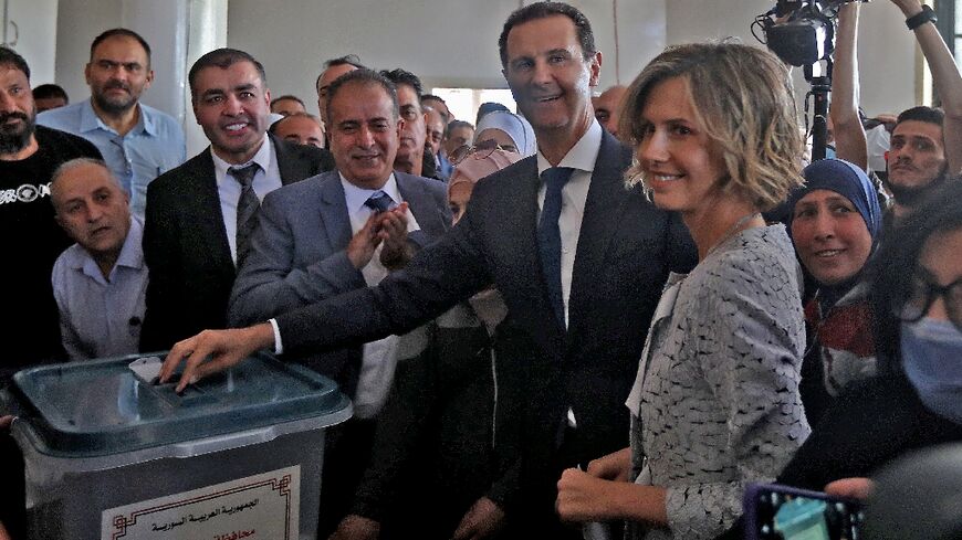 Syrian President Bashar al-Assad (center) and his wife Asma (right) cast votes in Douma near Damascus in May 2021