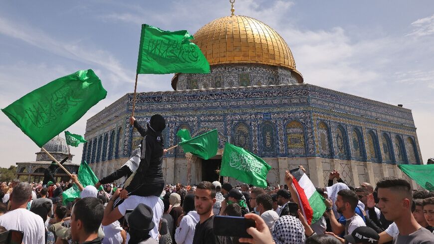 Palestinians wave national and Islamic flags inside Jerusalem's Al-Aqsa Mosque complex following prayers of the third Friday of the Muslim holy month of Ramadan