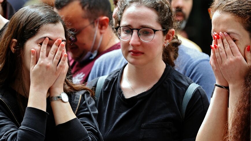 Israelis react at the site of a shooting attack the previous night on Dizengoff Street in the centre of Israel's Mediterranean coastal city of Tel Aviv 