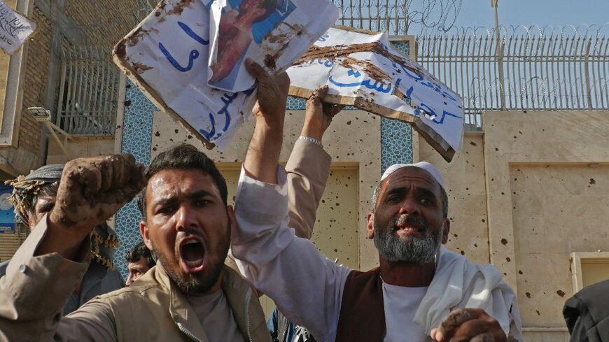 Afghan protesters shout slogans during a demonstration against the alleged published reports of harassment of Afghan refugees in Iran, outside of the Iranian consulate in Herat on April 11, 2022