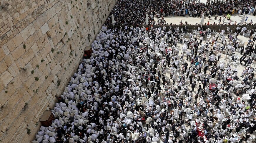 Jewish worshippers take part in prayers during the Passover holiday at the Western Wall in Jerusalem's Old City on April 18, 2022