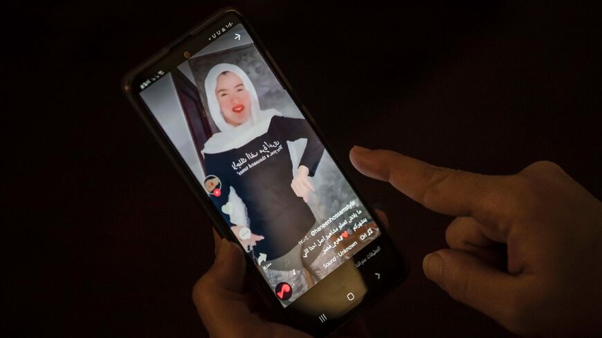 A woman watches a video of Egyptian influencer Haneen Hossam on the video-sharing app TikTok in Egypt's capital Cairo on July 28, 2020