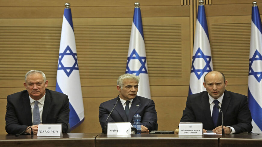 Israel's incoming Prime Minister Naftali Bennett gives an address before the new Cabinet, accompanied by Alternate Prime Minister and Foreign Minister Yair Lapid and Defense Minister Benny Gantz at the Knesset, Jerusalem, June 13, 2021.