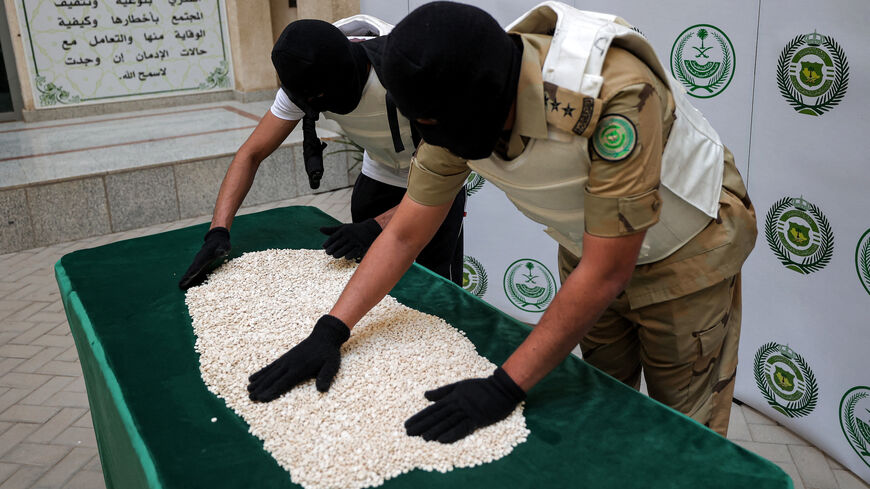 Officers of the Directorate of Narcotics Control of Saudi Arabia's Interior Ministry sort through tablets of captagon.