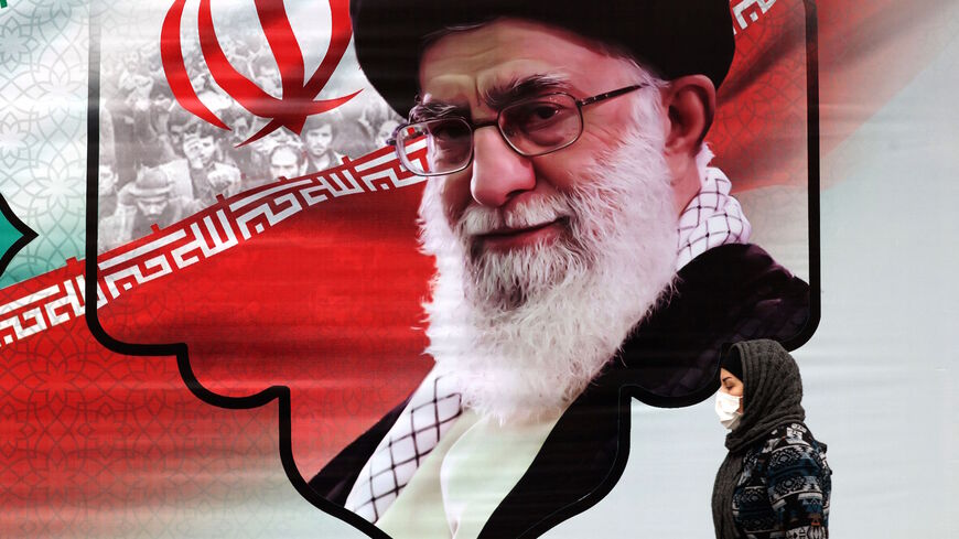 An Iranian woman walks past a mural showing Iran's Supreme Leader Ayatollah Ali Khamenei in the capital Tehran on March 9, 2022. 