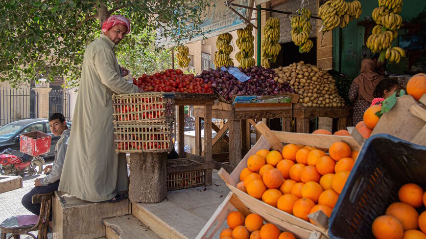 An Egyptian man arranges fruits at a shop in a market in Cairo, on March 17, 2022. Soaring bread prices sparked by Russia's invasion of Ukraine have bitten into the purchasing power of consumers in Egypt, a leading importer of wheat from the former Soviet states.