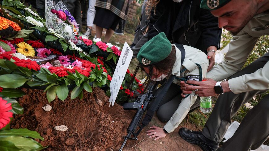 An Israeli border policewoman is comforted as she mourns next to the grave of her killed colleague Shirel Aboukrat.