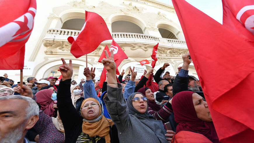 Tunisians raise national flags as they take to the streets of the capital to protest against their president, Tunis, Tunisia, April 10, 2022.