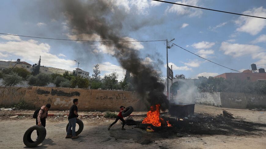 Palestinian children burn tyres following an earler an Israeli military raid in Jenin in the occupied West Bank on April 12, 2022. 