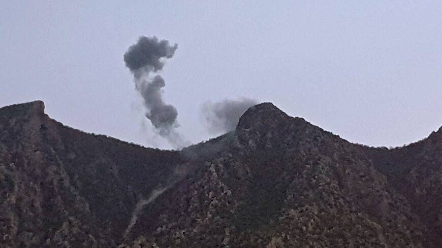 A picture taken on April 19, 2022 shows smoke billowing from behind the mountains of Matin (Jabal Matin) in the town of Chiladze following a Turkish offensive targeting rebels in the northern Iraqi Kurdish autonomous region.