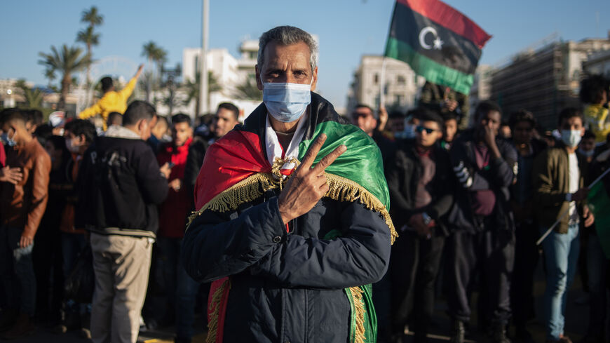 People wave flags and chant slogans during a gathering to commemorate the 10th anniversary of the Arab Spring in Martyrs Square, Tripoli, Libya, Feb. 17, 2021.