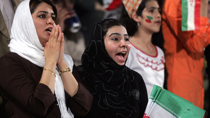 Iranian women, holding national flags, jubilate following their team's victory over Qatar at Doha's al-Gharrafa stadium during their World Cup 2006 qualifying match Oct. 13, 2004. 