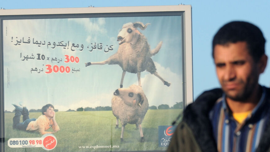 A Moroccan passes by an advertising billboard for a sheep purchase loan ahead of Aid el-Kebir holiday on Nov. 26, 2009, in Rabat. 