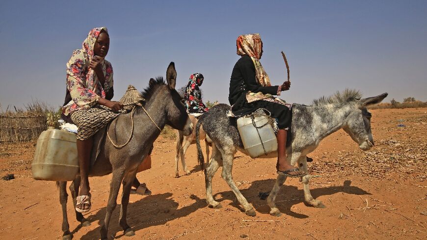 Sudanese women transport water in Darfur: the arid region remains awash with weapons and has seen a renewed spike in deadly violence in recent months triggered by disputes mainly over land, livestock and access to water and grazing