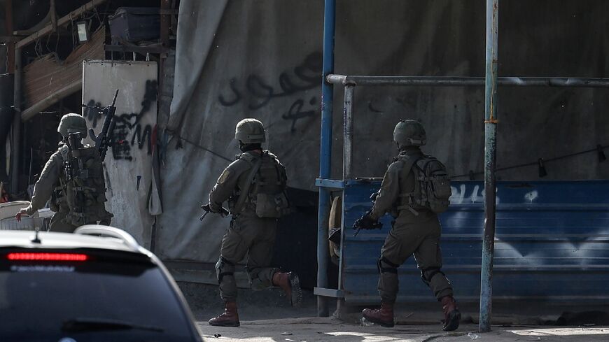Israeli troops take position in the Nur Shams Palestinian refugee camp near in the northern West Bank town of Tulkarem  during a raid looking for suspects related to a Palestinian suspect blamed for a shooting that killed three Israelis in Tel Aviv