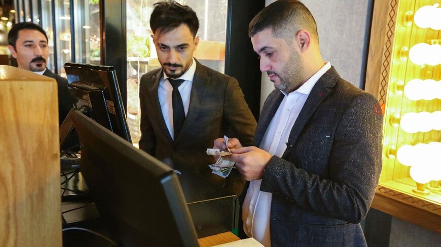 Restaurant manager Akram Johari (R) is among thousands of Lebanese who have fled to Iraq seeking a livelihood as his own country is mired in deep economic crisis